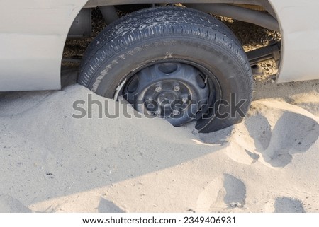 Tire wheel of car stuck in the sand near the beach Royalty-Free Stock Photo #2349406931