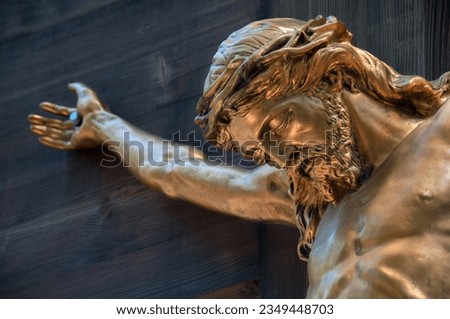 Bronze sculpture of crucified Jesus. Selective focus area. Royalty-Free Stock Photo #2349448703