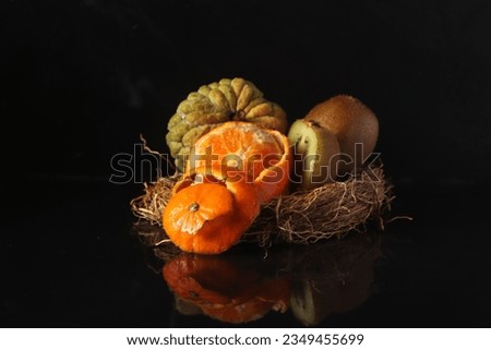 Plate with different fruit on kitchen table on dark background