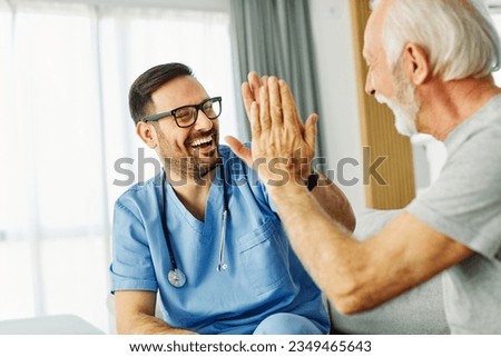 Doctor or nurse caregiver with senior man giving high five at home or nursing home Royalty-Free Stock Photo #2349465643