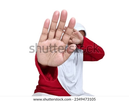 Asian woman in hijab, scared expression, hands forward showing rejection. Isolated on white background.