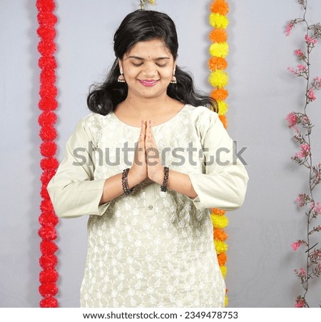 Happy young Indian girl posing with Ganesha statue on the occasion of Ganesh Festival                            