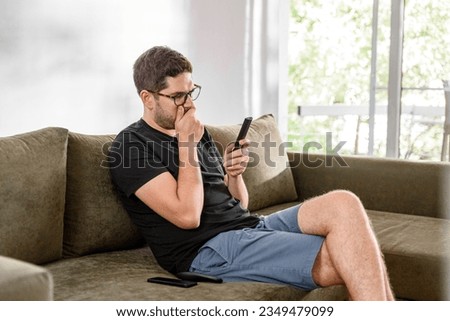 Glasses young man watching television and chill alone and decide to what will watching on pay tv