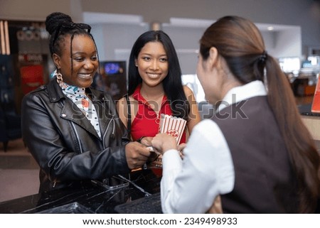 Two females Buying movie ticket from Cinema ticket seller counter Royalty-Free Stock Photo #2349498933