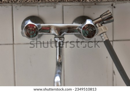 A detailed capture of an aged chrome faucet, reflecting years of use and timeless design.