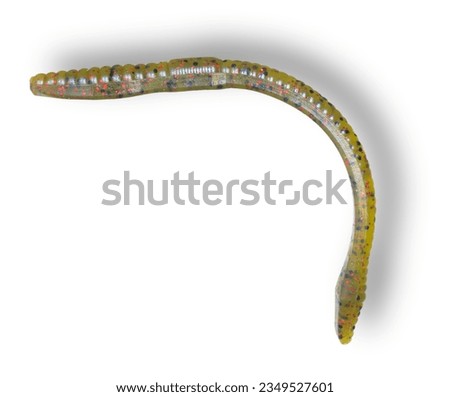 Transluscent light tan and yellow rubber fishing worm with black and red specs and shadow
