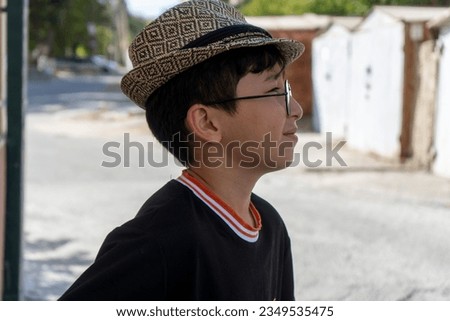 a asian boy with a cap in a street in  a hot weather