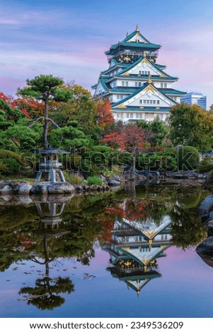 Osaka Castle reflecting in pond in Japanese Garden at dawn, Kansai, Japan