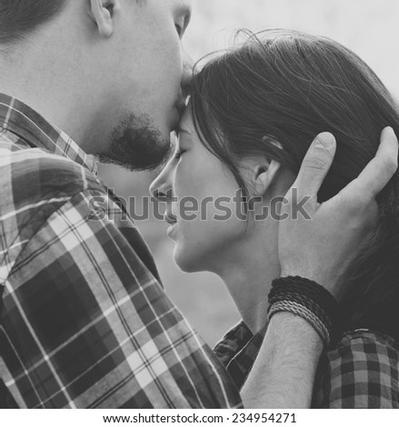 Close-up image of couple in love, man kisses a woman. Used filters instagram Black-white photo.