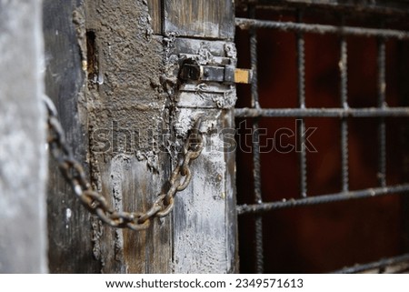 An old wooden door with a window for serving food in a prison, in a dungeon Royalty-Free Stock Photo #2349571613