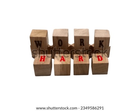 some small wooden blocks saying "work hard" are on a white background