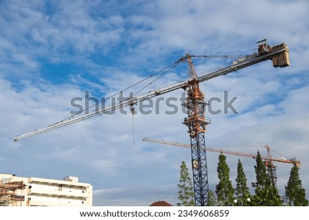 Construction crane and construction of new building by the roadside and trees. The photo is out of focus, blurred, and noisy, Gadjah Mada University campus  Royalty-Free Stock Photo #2349606859