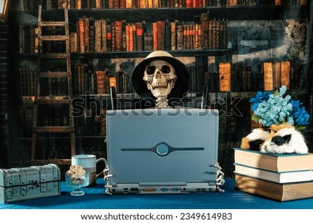 skeleton in hat on laptop computer in old library with coffee and gingerbread cookies