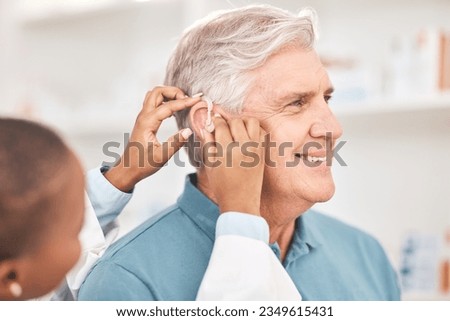 Helping, man and doctor with hearing aid, technology or healthcare or medical device consultation for deaf patient with tinnitus. Listening, test and exam ear tech with nurse or senior male in clinic Royalty-Free Stock Photo #2349615431