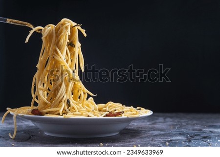 a picture of spaghetti with tomato sauce with meat on a fork,Delicious bacon and tomato sauced spaghetti presented on a dish,basil in a dish,Italian meal, spaghetti with copy space
