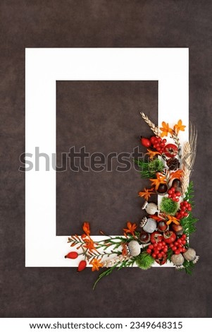 Nature background border for Thanksgiving and Autumn Fall harvest festival season with flowers, berry fruit, nuts with white frame on brown lokta paper.  