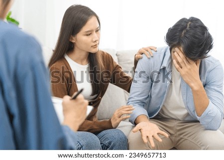 Psychology, depression asian young couple love, woman, man patient consulting problem mental health with psychologist, psychiatrist at clinic together, wife encouraging husband,  therapy health care.