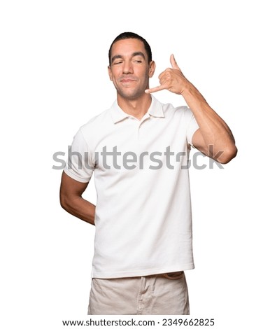 Hesitant young man making a gesture of calling with the hand
