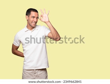 Happy young man using his hands like a binoculars