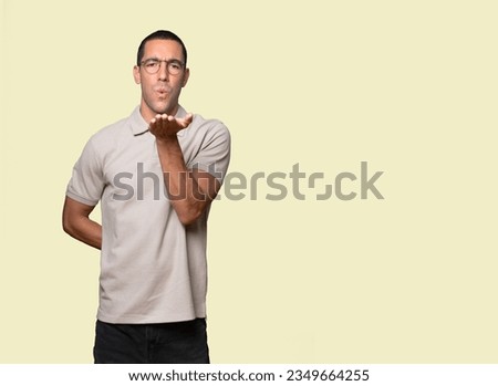 Friendly young man making a gesture of taking a photo with the hands