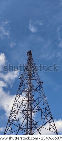 
Photo from below of a cellular telecommunications tower with a clear sky in the background.