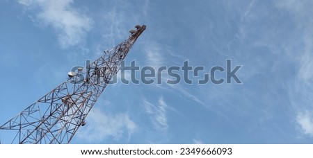 
Photo from below of a cellular telecommunications tower with a clear sky in the background.