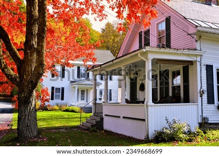 White wooden houses with vibrant red maple tree during autumn in New England, USA Royalty-Free Stock Photo #2349668699