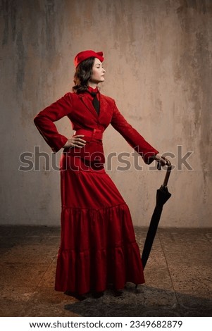 A stylish lady in a red old-fashioned suit with a hat and a lace umbrella Royalty-Free Stock Photo #2349682879