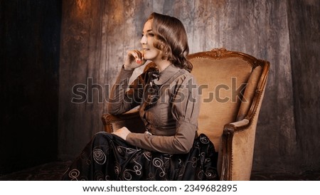 A stylish lady in an elegant Victorian-style suit, sitting in an armchair. costume with steampunk elements, Royalty-Free Stock Photo #2349682895