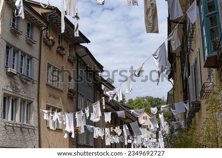 White clothes hanging on wires at the old town of Swiss City of Baden on a sunny summer day at famous fun fair named Badenfahrt. Photo taken August 19th, 2023, Baden, Canton Aargau, Switzerland.