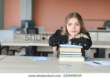 Teen girl studying with textbook writing essay learning in classroom Royalty-Free Stock Photo #2349698769