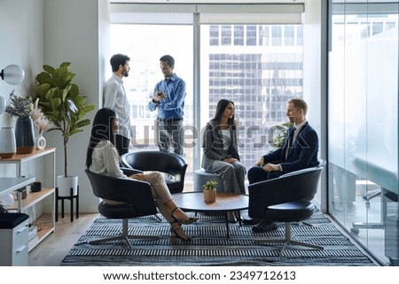 Busy diverse professional team business people workers talking in modern corporate office lobby. Multicultural coworkers group having teamwork conversation together at work meeting. Authentic shot Royalty-Free Stock Photo #2349712613