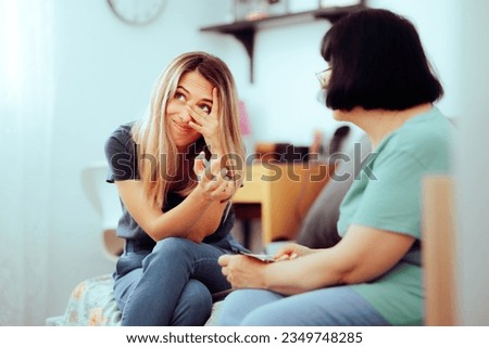 
Funny Woman Embarrassed by her Family Childhood Photos. Shy girl checking old vintage pictures from her infant years
