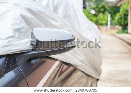 A car with cover sheet for sunlight protection. Royalty-Free Stock Photo #2349780705