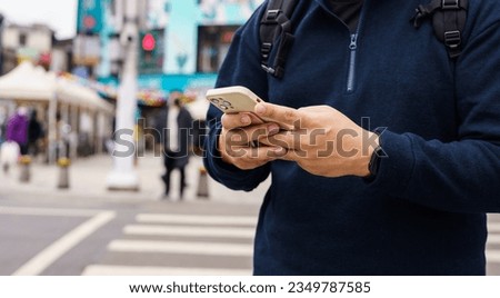 Man in downtown city street ordering taxi using smart phone app Booking taxi using application online on smart phone.