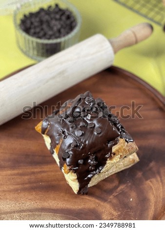 A picture of a baked good named chocolate chip pastry. This baked products have flaky layers and melted chocolate

It is consumed as dessert or afternoon snacks, with coffee or tea
