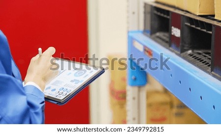 Worker checking inventory on a tablet warehouse management system. Royalty-Free Stock Photo #2349792815