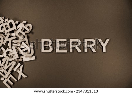 BLUEBERRY in wooden English language capital letters spilling from a pile of letters in black and white