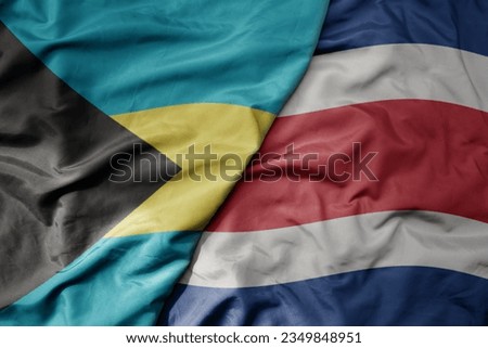 big waving realistic national colorful flag of bahamas and national flag of costa rica . macro