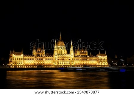 View of the illuminated Hungarian Parliament Building at night from the opposite bank