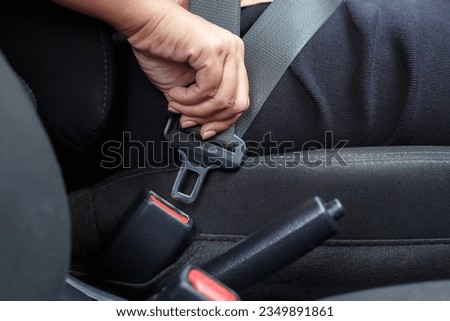 Close up of woman hand buckle the car safety belt. Royalty-Free Stock Photo #2349891861