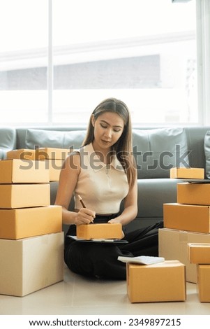 Asian businesswoman on sofa using laptop computer check customer's online delivery box order at home Starting SMEs, Small Business Entrepreneurs, Freelance Online Business Vertical picture