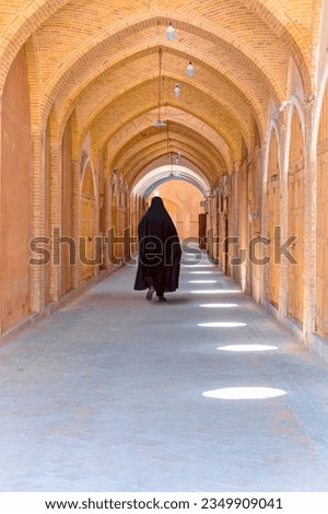 Iranian  woman walks in a completely close grand bazaar - Shiraz, iran    
