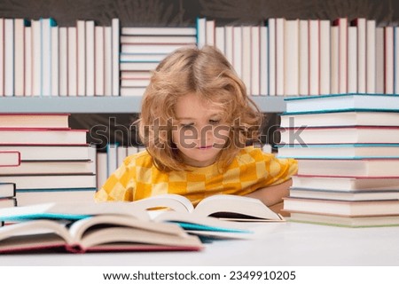 Education Concept. School child studying in school library. Kid reading book in library on bookshelf background.