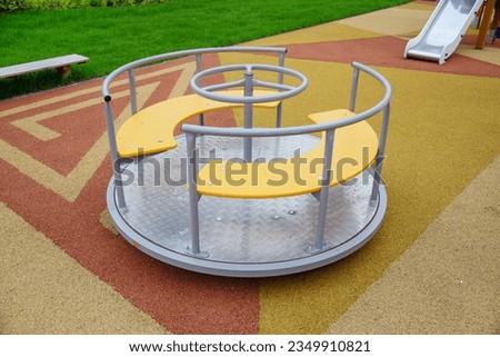 A carousel on a beautiful rubberized surface in the form of triangles on the playground in kindergarten on a clear sunny day. Playgrounds, toys, sports.