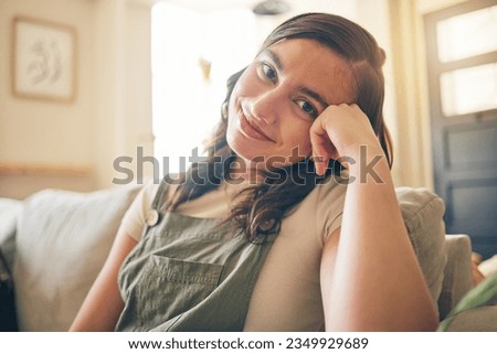 Happy, smile and portrait of woman on a sofa relaxing in the living room of her apartment. Calm, peaceful and face of young female person from Canada with positive attitude sitting in lounge at home.