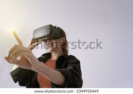 Happy young girl playing virtual reality game in vr headset glasses