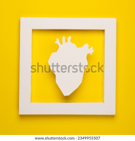 White anatomical heart in white frame on yellow background. Creative layout. Minimalism