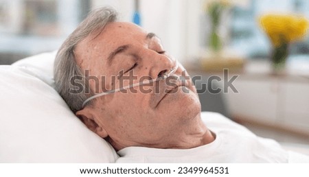 Oxygen, hospital bed and senior man sleeping with ventilation and breathing tube support in a clinic. Elderly patient, medical care and emergency room with male person at a doctor for healthcare Royalty-Free Stock Photo #2349964531