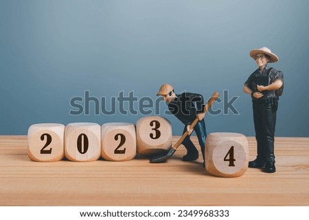 Wooden blocks with change 2023 to 2024 number with mini worker.